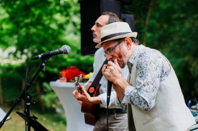 Groupe de personnes discutant sur une terrasse éclairée, entourée de végétation et de bougies.