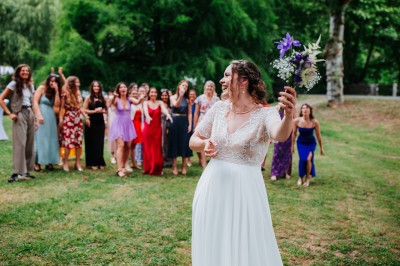 Groupe de personnes discutant sur une terrasse éclairée, entourée de végétation et de bougies.