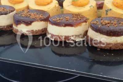 Verres de cocktail orange garnis de tranches d'orange et de pailles noires, disposés sur une nappe noire.