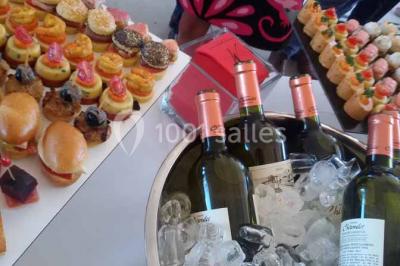 Verres de cocktail orange garnis de tranches d'orange et de pailles noires, disposés sur une nappe noire.