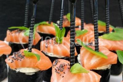 Jambon sur support, bol de tartare et croûtons disposés sur une table devant un mur en briques.