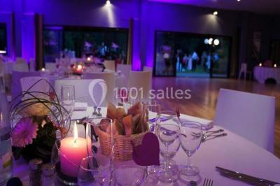 Jambon sur support, bol de tartare et croûtons disposés sur une table devant un mur en briques.