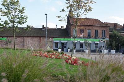 Jambon sur support, bol de tartare et croûtons disposés sur une table devant un mur en briques.