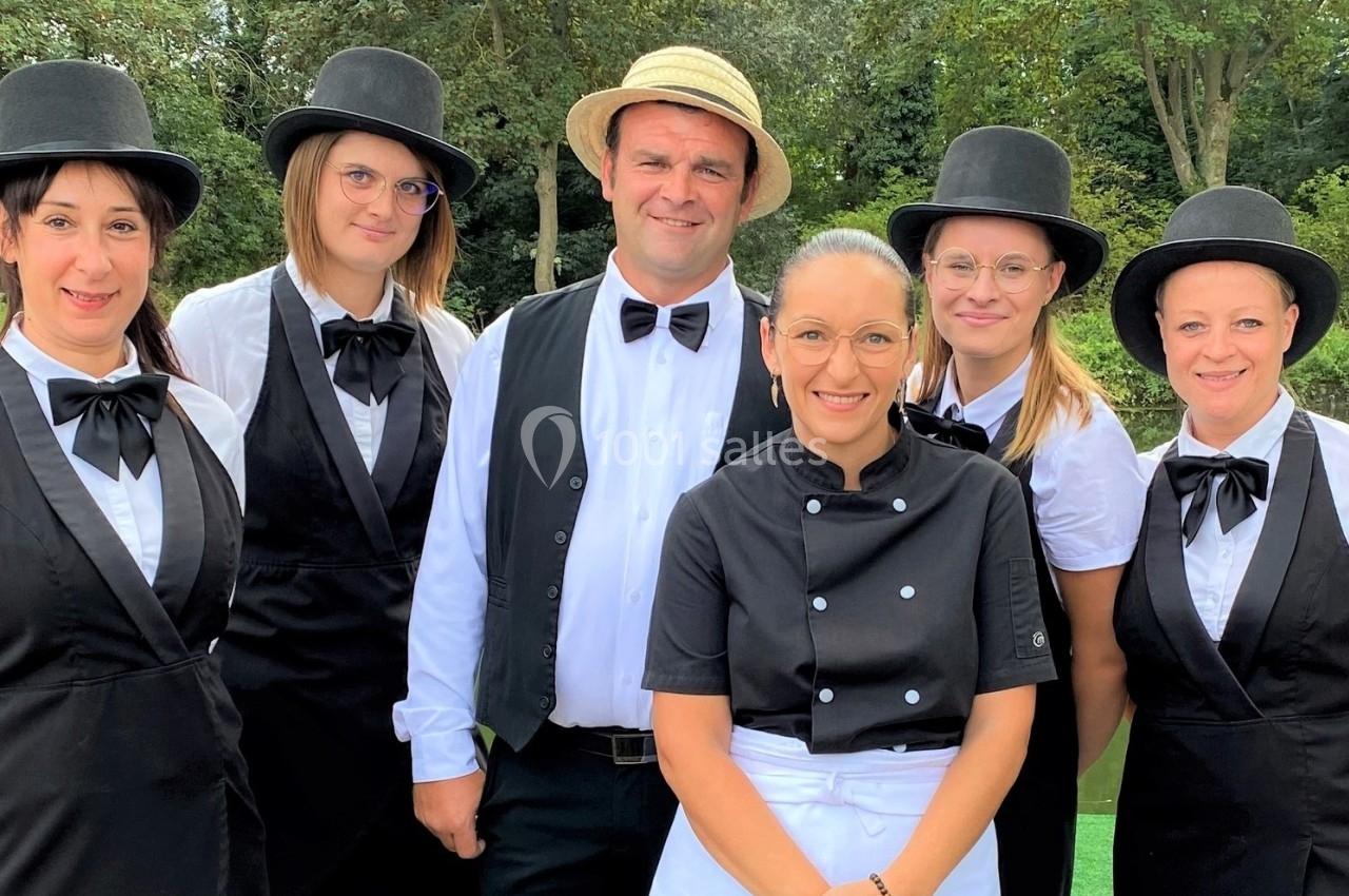 Un groupe de six personnes en tenue professionnelle posant devant un plan d'eau et des arbres.