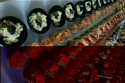 Table en bois décorée de bougies, fleurs et feuillage, entourée de chaises, sous une arche végétale dans une salle lumineuse.