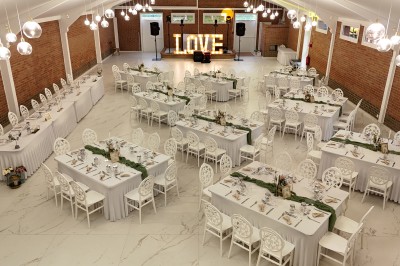 Miniature Location salle Paillencourt (Nord) - Le Canotier #5 Salle de réception décorée avec des tables rondes blanches, nappes élégantes et chaises assorties, prête pour un événement.