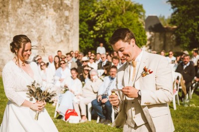Bâtiment en pierre éclairé la nuit, avec un ciel bleu foncé en arrière-plan et un jardin sombre au premier plan.