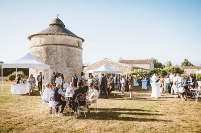 Bâtiment en pierre éclairé la nuit, avec un ciel bleu foncé en arrière-plan et un jardin sombre au premier plan.