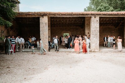 Bâtiment en pierre éclairé la nuit, avec un ciel bleu foncé en arrière-plan et un jardin sombre au premier plan.
