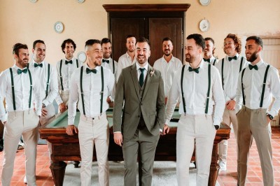 Bâtiment en pierre éclairé la nuit, avec un ciel bleu foncé en arrière-plan et un jardin sombre au premier plan.