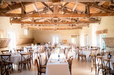 Bâtiment en pierre éclairé la nuit, avec un ciel bleu foncé en arrière-plan et un jardin sombre au premier plan.