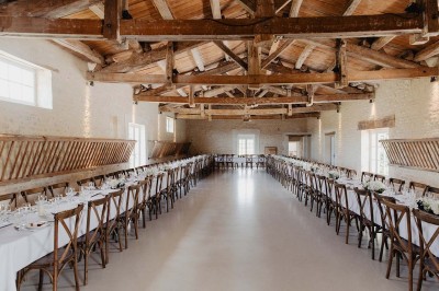Bâtiment en pierre éclairé la nuit, avec un ciel bleu foncé en arrière-plan et un jardin sombre au premier plan.