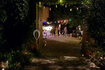 Blason sculpté en pierre, usé par le temps, fixé sur un mur ancien avec des branches visibles au-dessus.