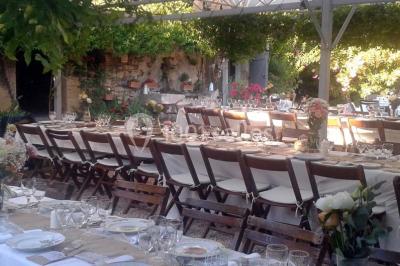 Blason sculpté en pierre, usé par le temps, fixé sur un mur ancien avec des branches visibles au-dessus.