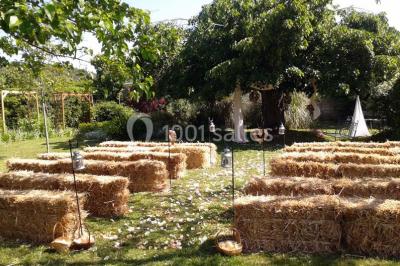 Blason sculpté en pierre, usé par le temps, fixé sur un mur ancien avec des branches visibles au-dessus.