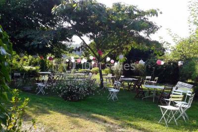 Blason sculpté en pierre, usé par le temps, fixé sur un mur ancien avec des branches visibles au-dessus.