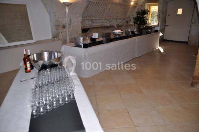 Blason sculpté en pierre, usé par le temps, fixé sur un mur ancien avec des branches visibles au-dessus.