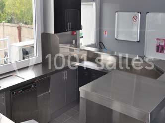 Salle de danse vide avec éclairage coloré, boules à facettes suspendues et reflets lumineux sur les murs.