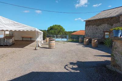 Tables décorées de nappes blanches, ornées de bougies entourées de fleurs, dans un cadre extérieur fleuri.