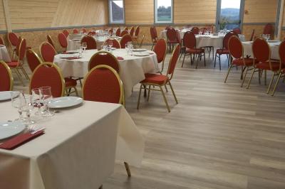Paysage rural avec une ferme traditionnelle entourée de champs verdoyants et d'arbres sous un ciel nuageux.