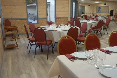 Paysage rural avec une ferme traditionnelle entourée de champs verdoyants et d'arbres sous un ciel nuageux.