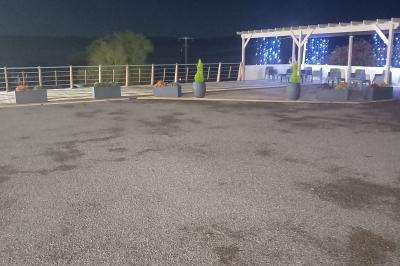 Paysage rural avec une ferme traditionnelle entourée de champs verdoyants et d'arbres sous un ciel nuageux.