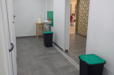 Paysage rural avec une ferme traditionnelle entourée de champs verdoyants et d'arbres sous un ciel nuageux.