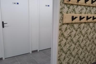 Paysage rural avec une ferme traditionnelle entourée de champs verdoyants et d'arbres sous un ciel nuageux.