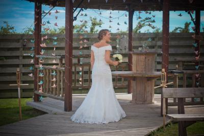 Paysage rural avec une ferme traditionnelle entourée de champs verdoyants et d'arbres sous un ciel nuageux.