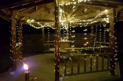 Paysage rural avec une ferme traditionnelle entourée de champs verdoyants et d'arbres sous un ciel nuageux.