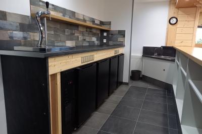 Paysage rural avec une ferme traditionnelle entourée de champs verdoyants et d'arbres sous un ciel nuageux.