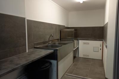 Paysage rural avec une ferme traditionnelle entourée de champs verdoyants et d'arbres sous un ciel nuageux.