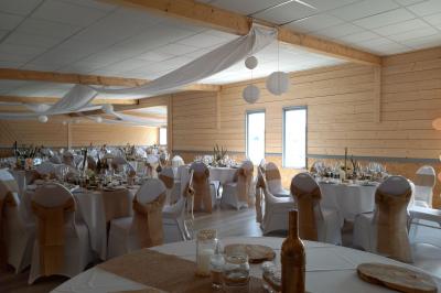 Paysage rural avec une ferme traditionnelle entourée de champs verdoyants et d'arbres sous un ciel nuageux.