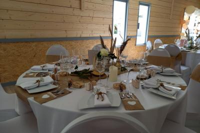 Paysage rural avec une ferme traditionnelle entourée de champs verdoyants et d'arbres sous un ciel nuageux.