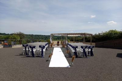 Paysage rural avec une ferme traditionnelle entourée de champs verdoyants et d'arbres sous un ciel nuageux.
