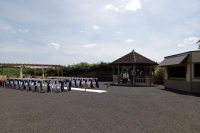 Paysage rural avec une ferme traditionnelle entourée de champs verdoyants et d'arbres sous un ciel nuageux.