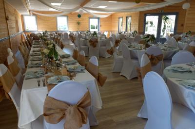 Paysage rural avec une ferme traditionnelle entourée de champs verdoyants et d'arbres sous un ciel nuageux.
