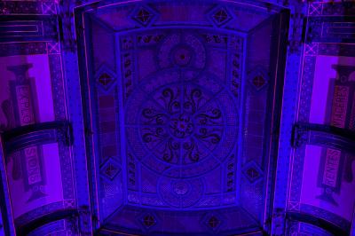 Groupe de personnes discutant dans un espace intérieur éclairé par des lumières vertes, ambiance conviviale.