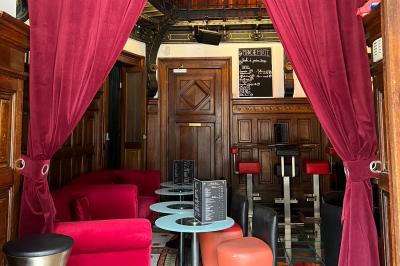 Groupe de personnes discutant dans un espace intérieur éclairé par des lumières vertes, ambiance conviviale.