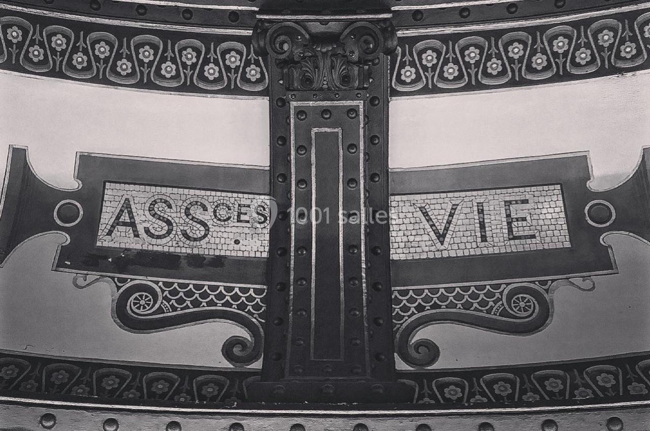 Motif décoratif en mosaïque avec les mots ’ASSURANCE VIE’ sur une structure métallique ornée.