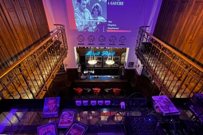 Groupe de personnes discutant dans un espace intérieur éclairé par des lumières vertes, ambiance conviviale.