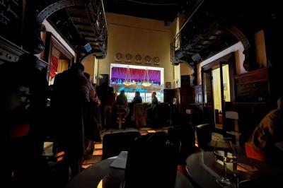 Groupe de personnes discutant dans un espace intérieur éclairé par des lumières vertes, ambiance conviviale.