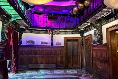 Groupe de personnes discutant dans un espace intérieur éclairé par des lumières vertes, ambiance conviviale.