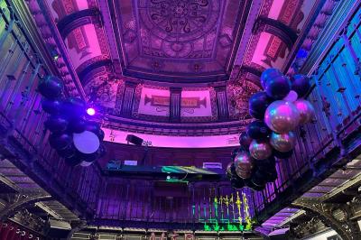 Groupe de personnes discutant dans un espace intérieur éclairé par des lumières vertes, ambiance conviviale.
