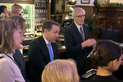 Groupe de personnes discutant dans un espace intérieur éclairé par des lumières vertes, ambiance conviviale.