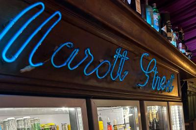 Groupe de personnes discutant dans un espace intérieur éclairé par des lumières vertes, ambiance conviviale.