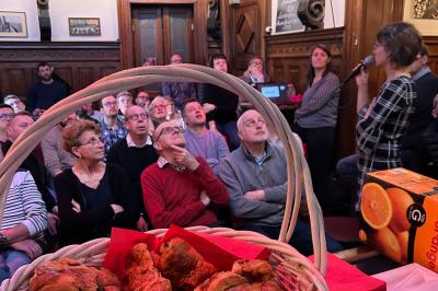 Groupe de personnes discutant dans un espace intérieur éclairé par des lumières vertes, ambiance conviviale.