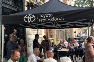 Groupe de personnes discutant dans un espace intérieur éclairé par des lumières vertes, ambiance conviviale.