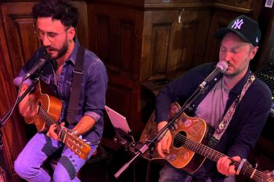 Groupe de personnes discutant dans un espace intérieur éclairé par des lumières vertes, ambiance conviviale.