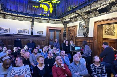 Bouteilles de vin inclinées et empilées horizontalement sur un présentoir en bois.